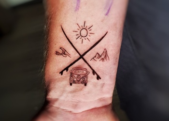 vw-bus-surfer-berge-mountains-sea-sun-tattoo-arm-man-